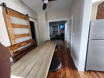 Dining area. Kitchen on the right, bathroom on the left with a sliding door and living room at the end.
