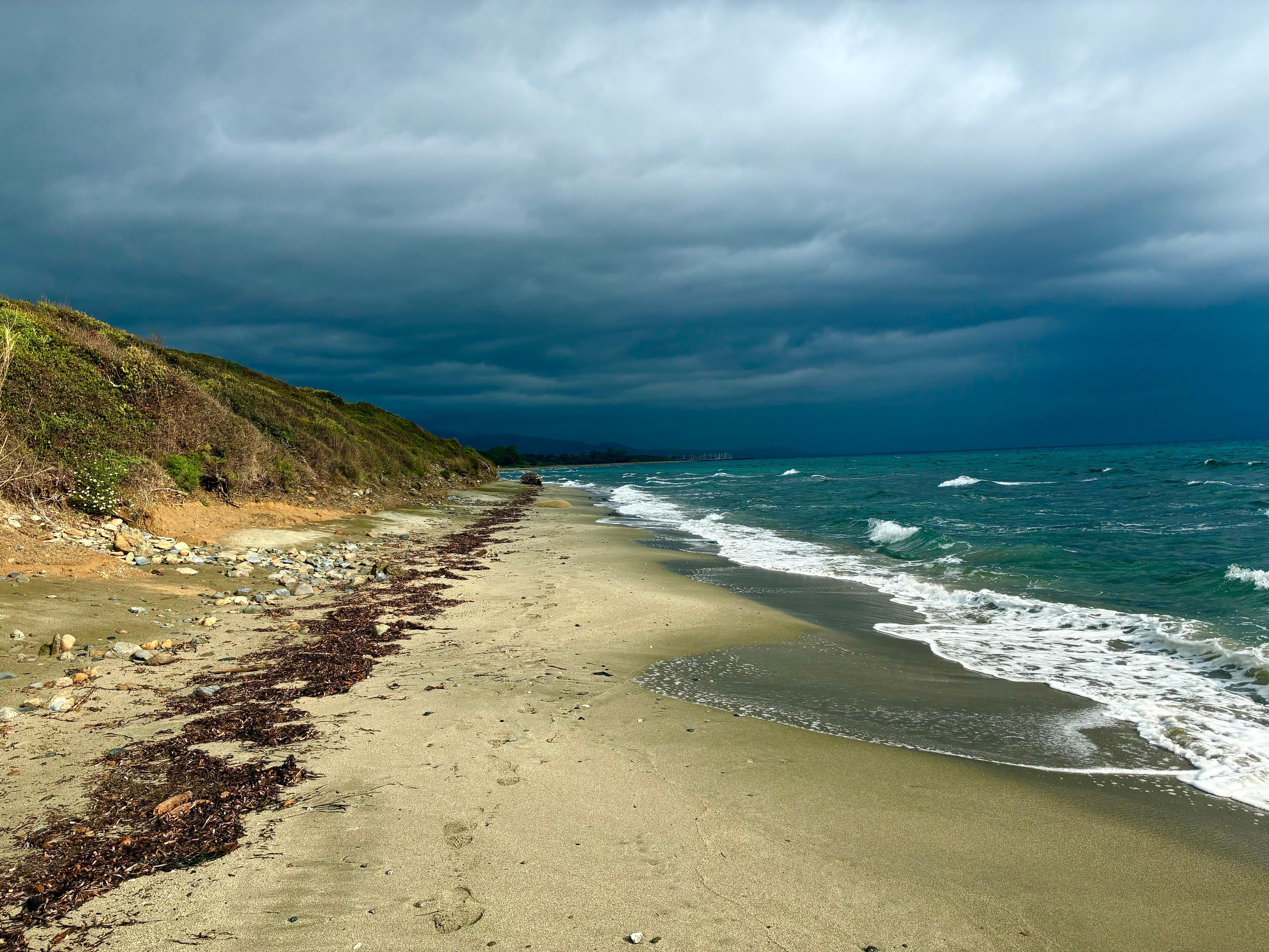 Angry skys over Olmello beach. Marina at the far end. 