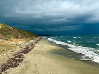 Angry skys over Olmello beach. Marina at the far end.