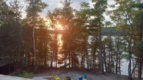 View from Cottage deck looking down on fire pit and at sunset.