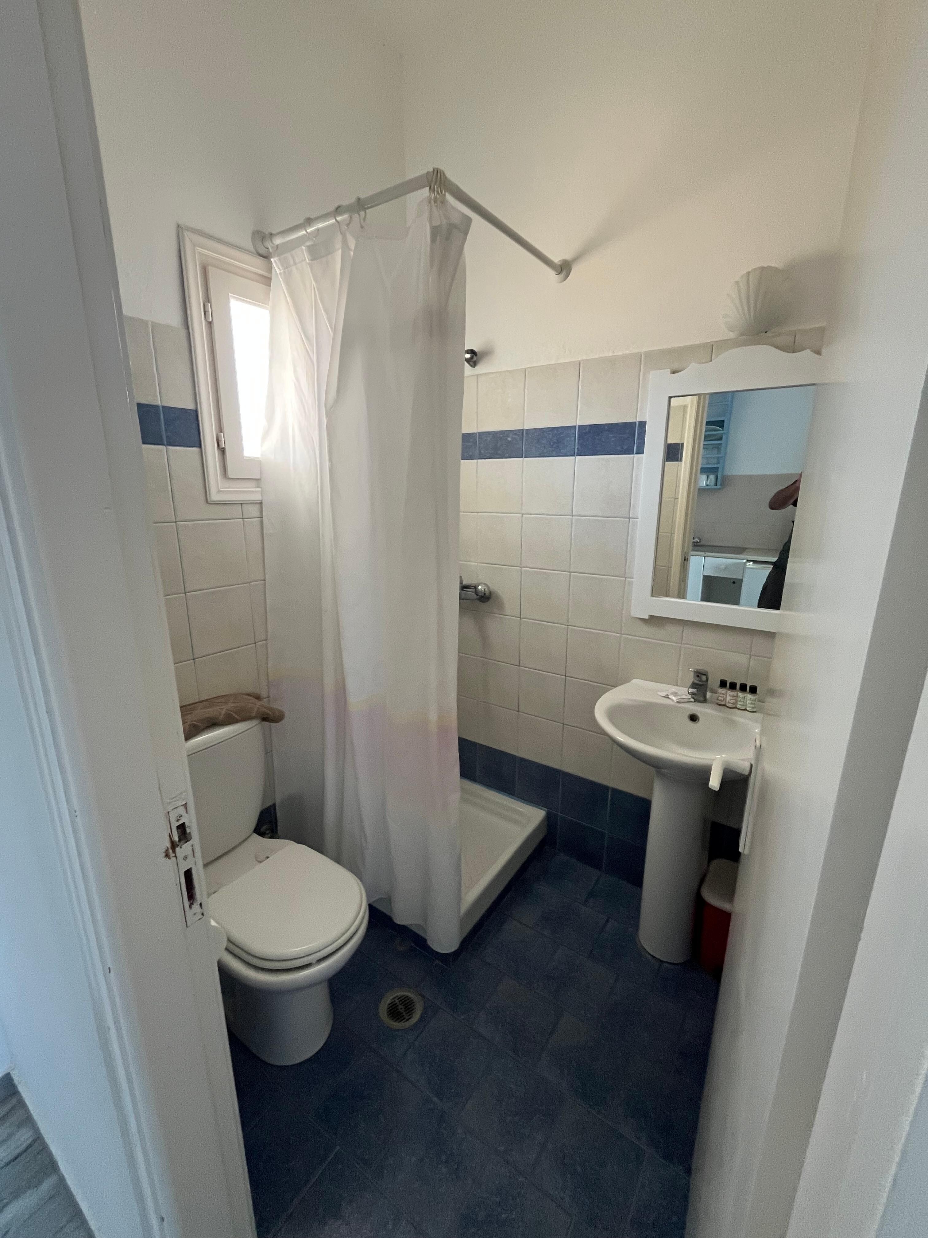 Salle de bain avec douche au rideau collant dommage 