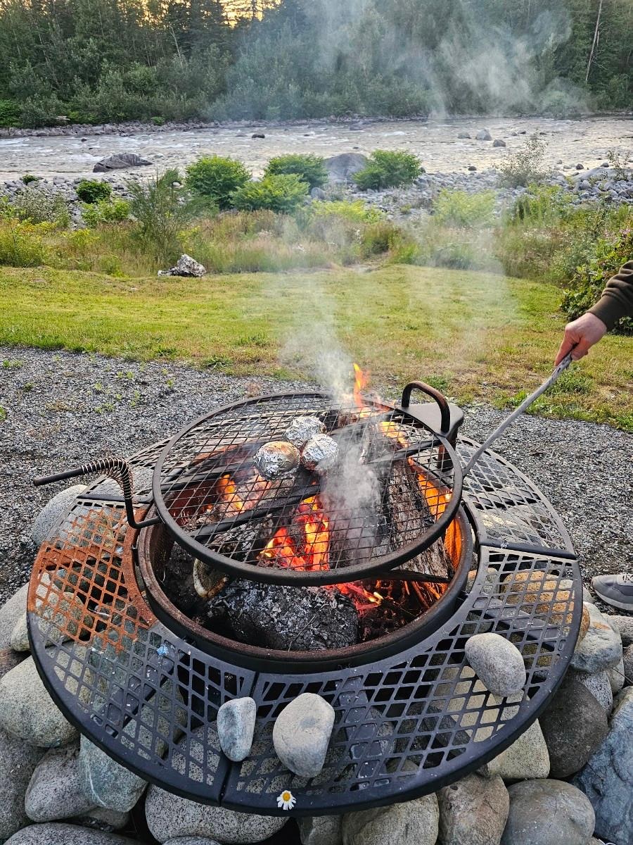 Wood fire pit with grill for cooking.