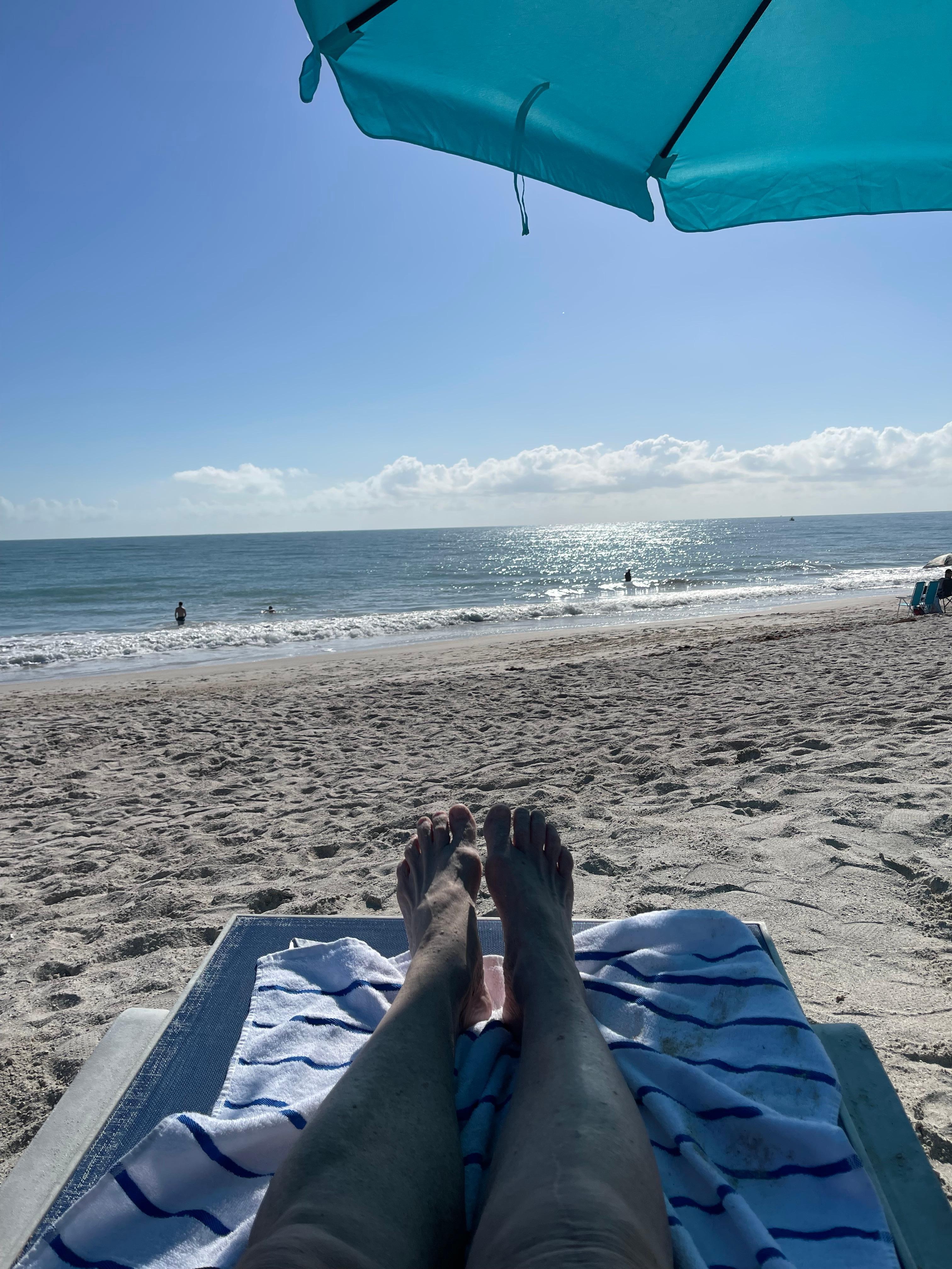 Lounging on beach in front of hotel. 