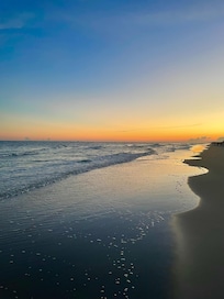 The beach in front of the house at sunset.