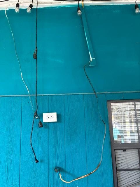 Hanging cords to the overhead lighting in the screened patio area.