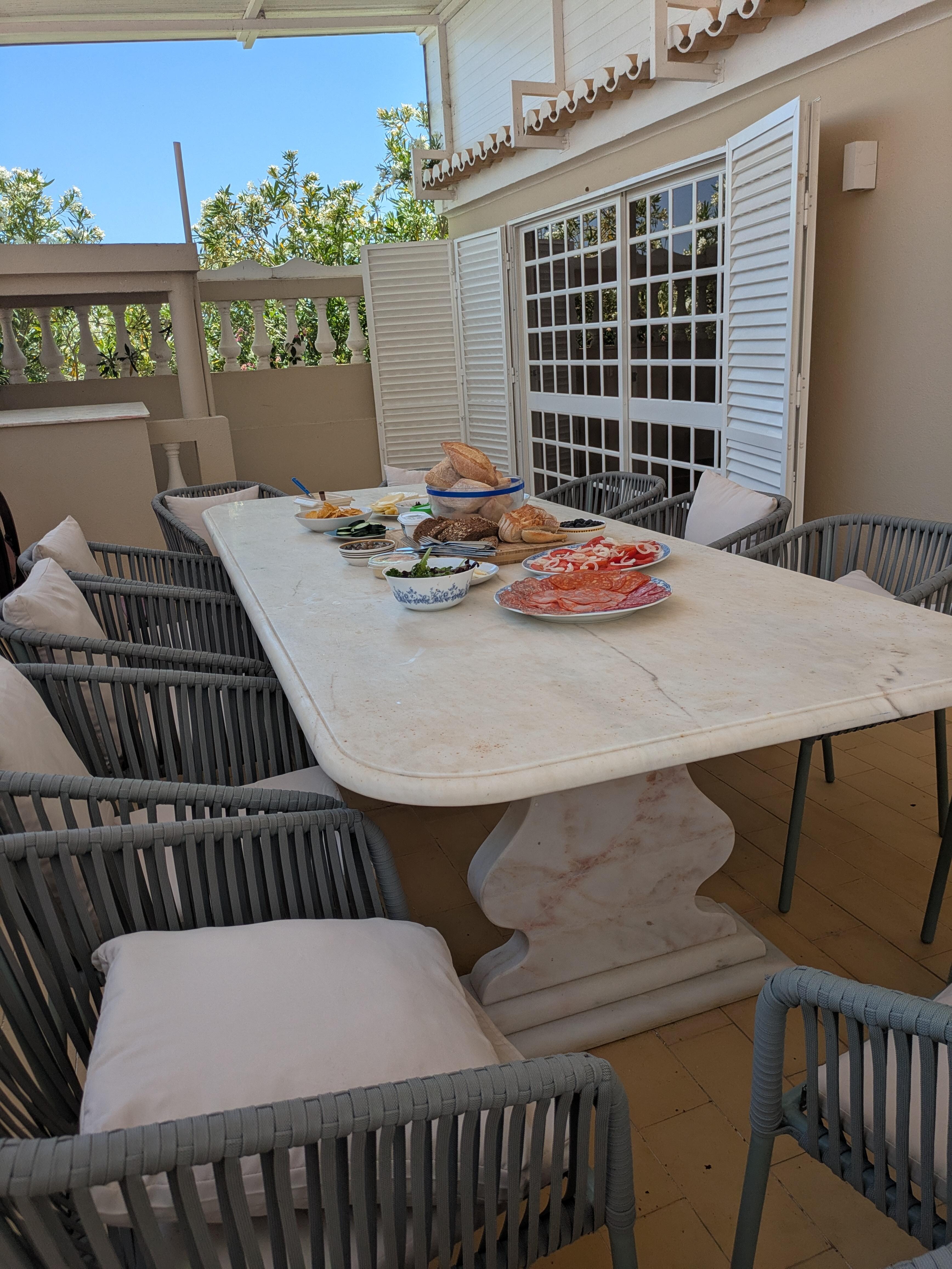 Large outdoor dining table with a bar room to the right. BBQ area is next to this.