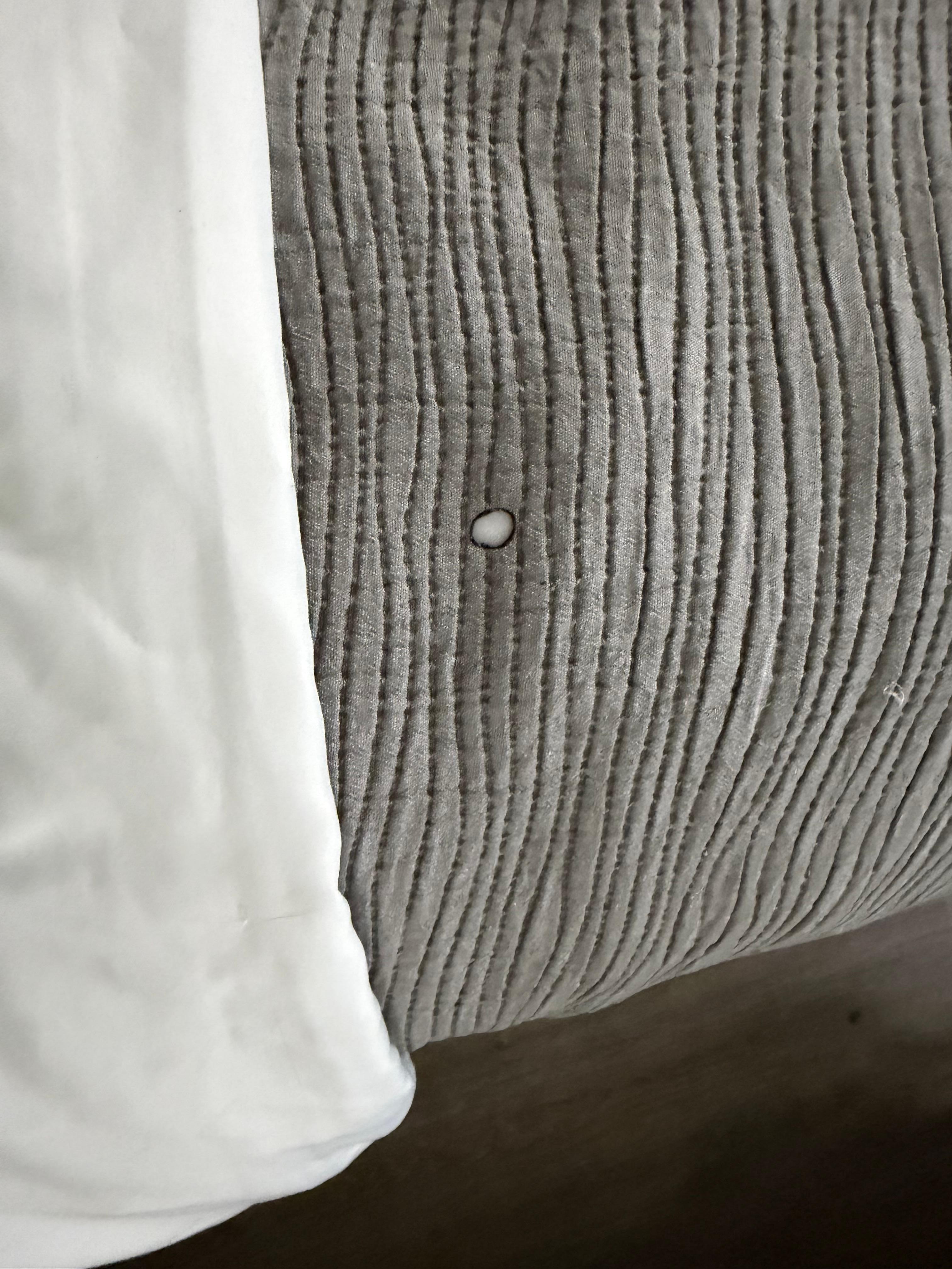 Cigarette burn on the bedspread 