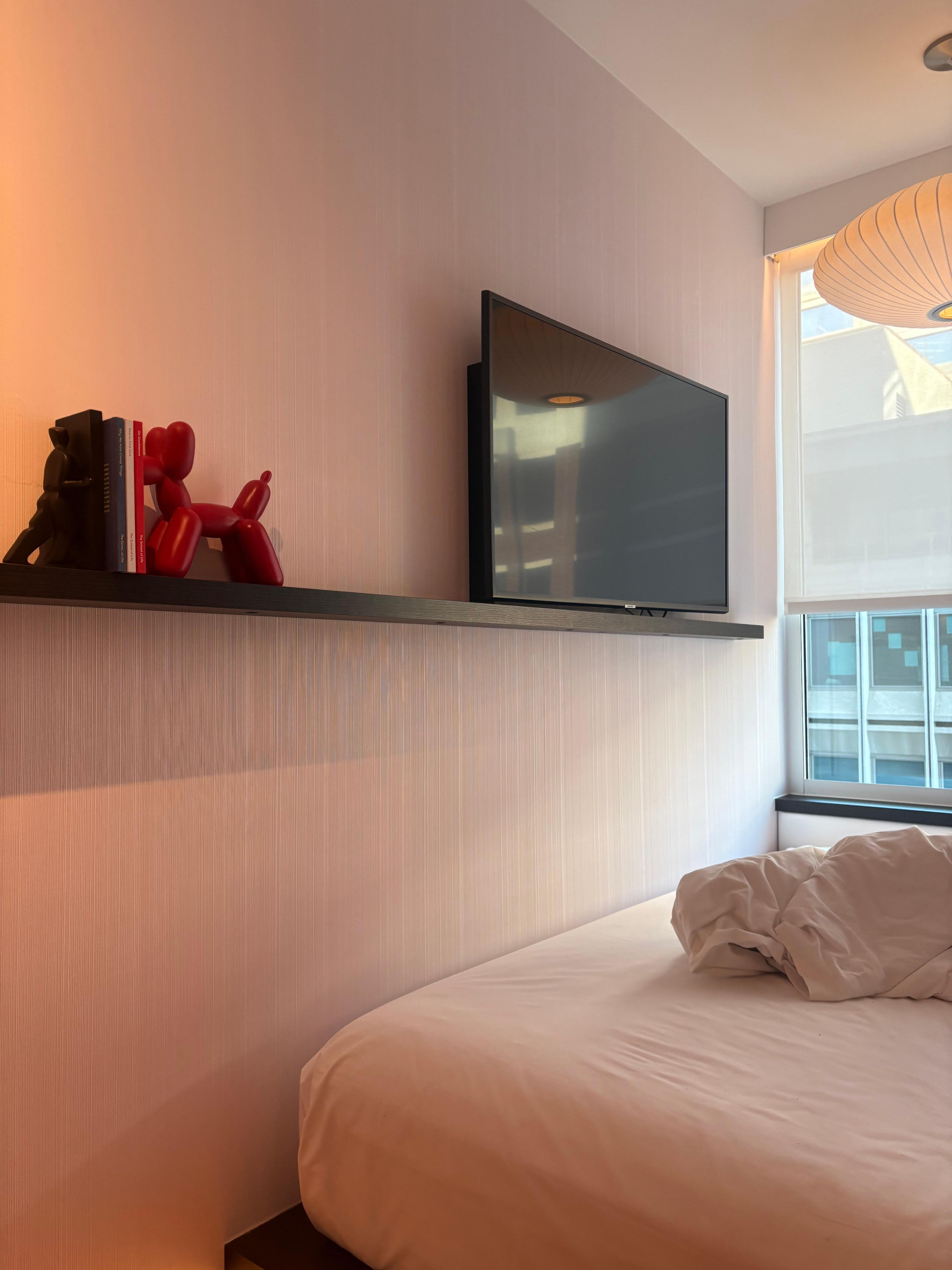 The tv and shelf above the bed.