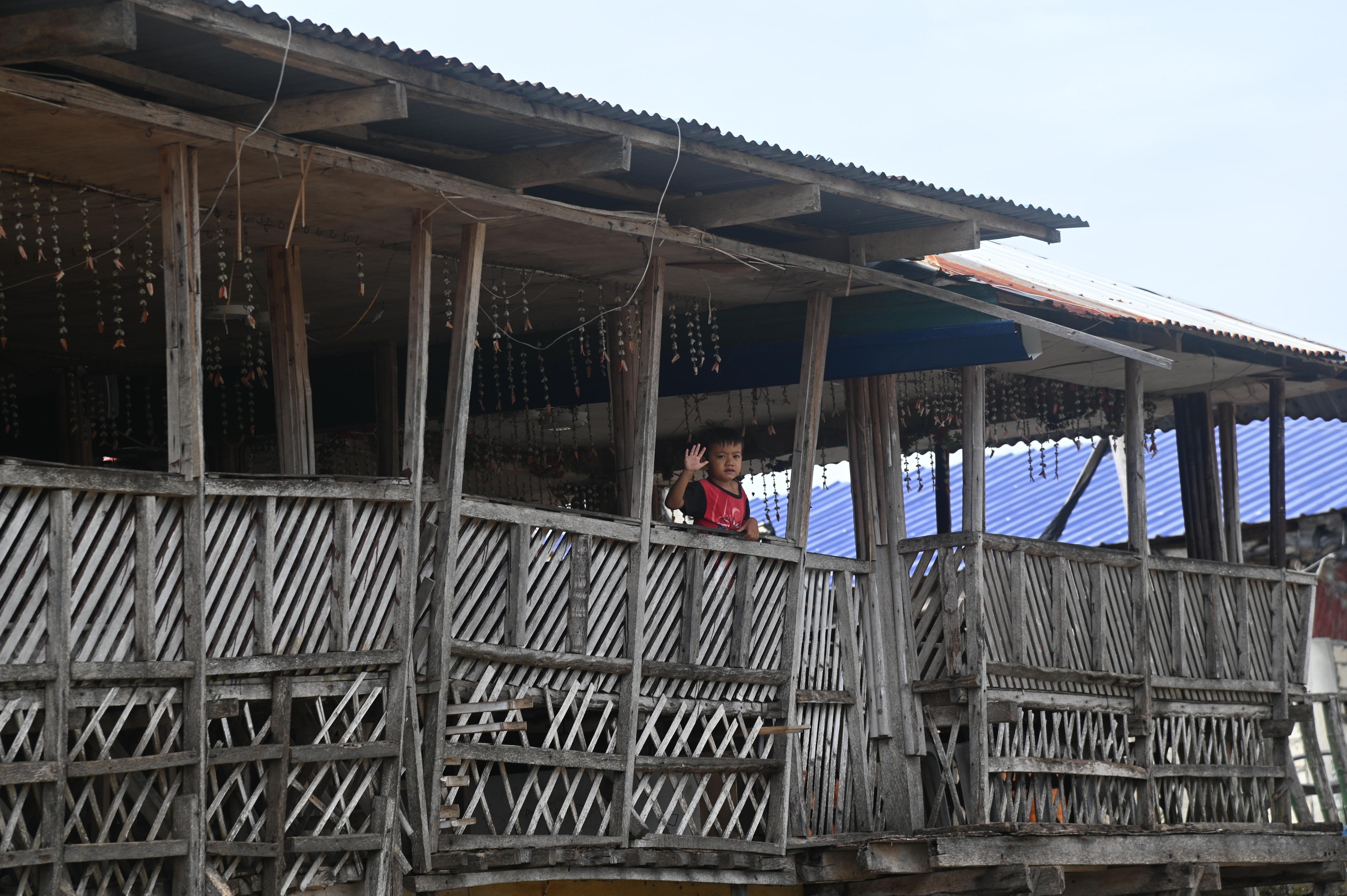 A friendly child waving to a photographer