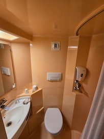 Plastic bathroom with no towels and prone to floor flooding
