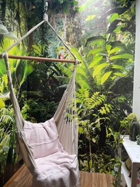 Hanging boho swing chair in a reading book corner.