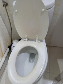 The toilet is dark and dirty.