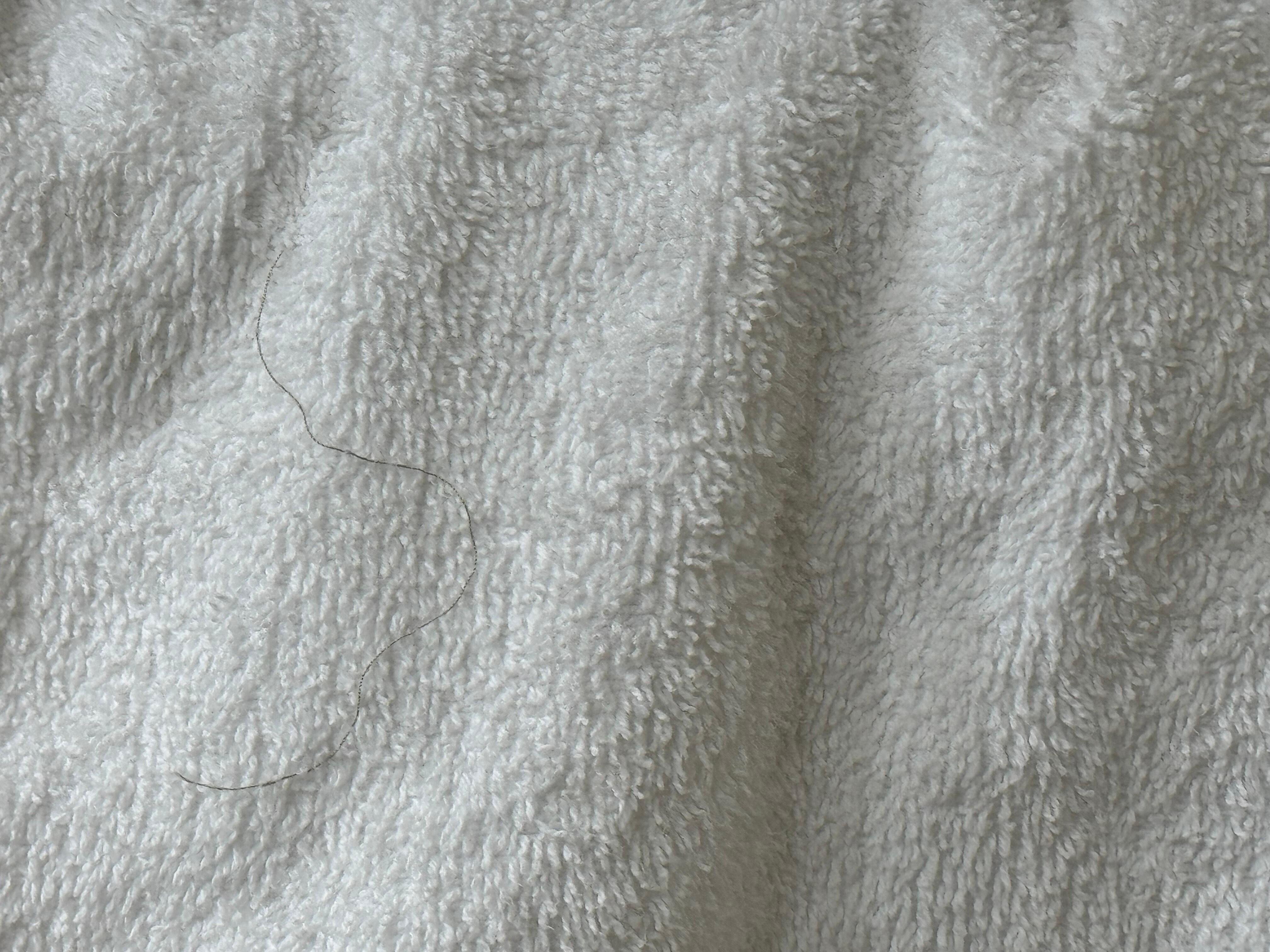 This towel has hair on it as though it had not been washed.  It is a close up of the the hanging towel above on the left.