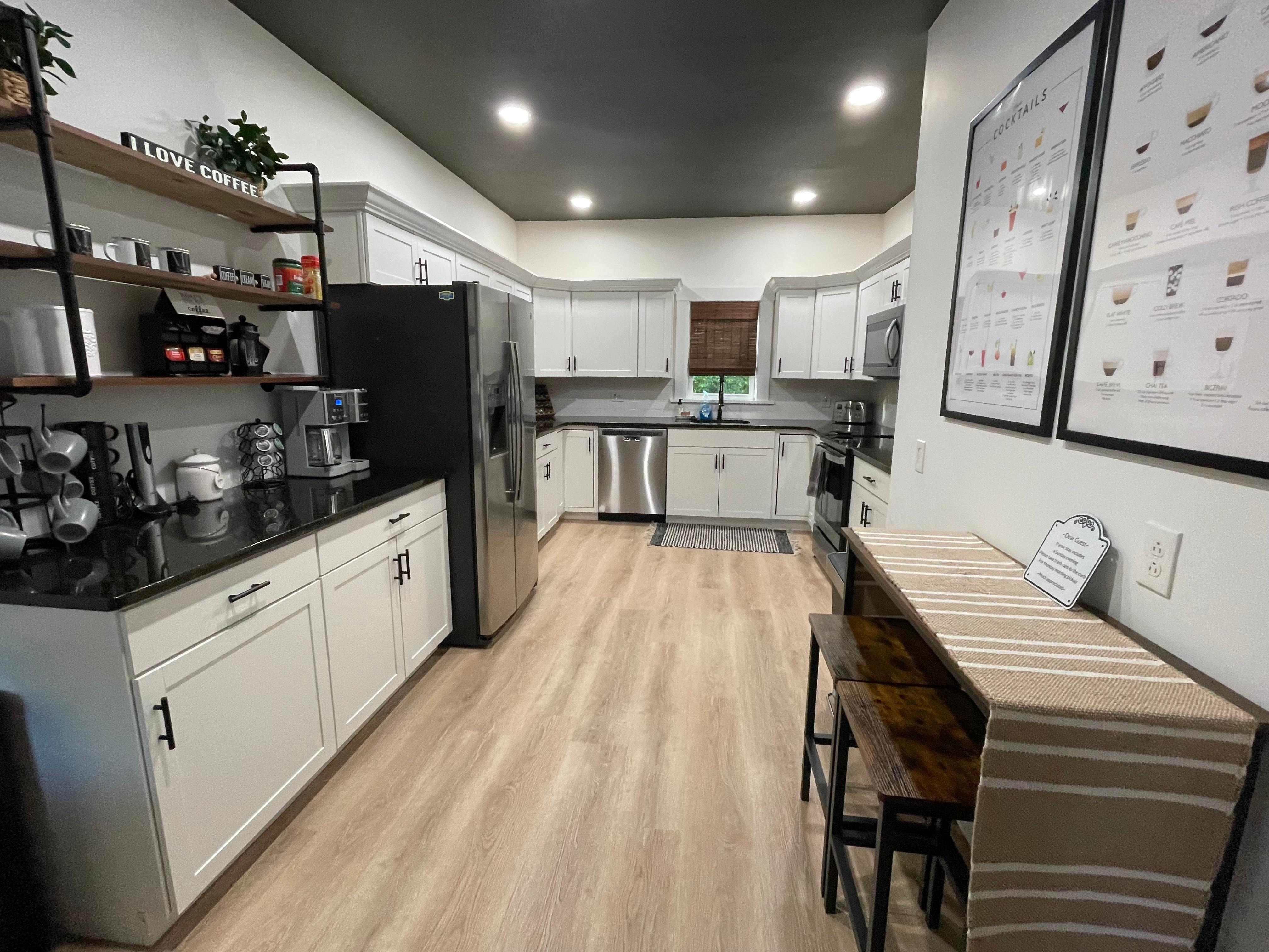 Kitchen prep area with bar table and stools which is a great workspace.