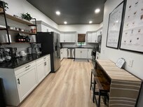 Kitchen prep area with bar table and stools which is a great workspace.