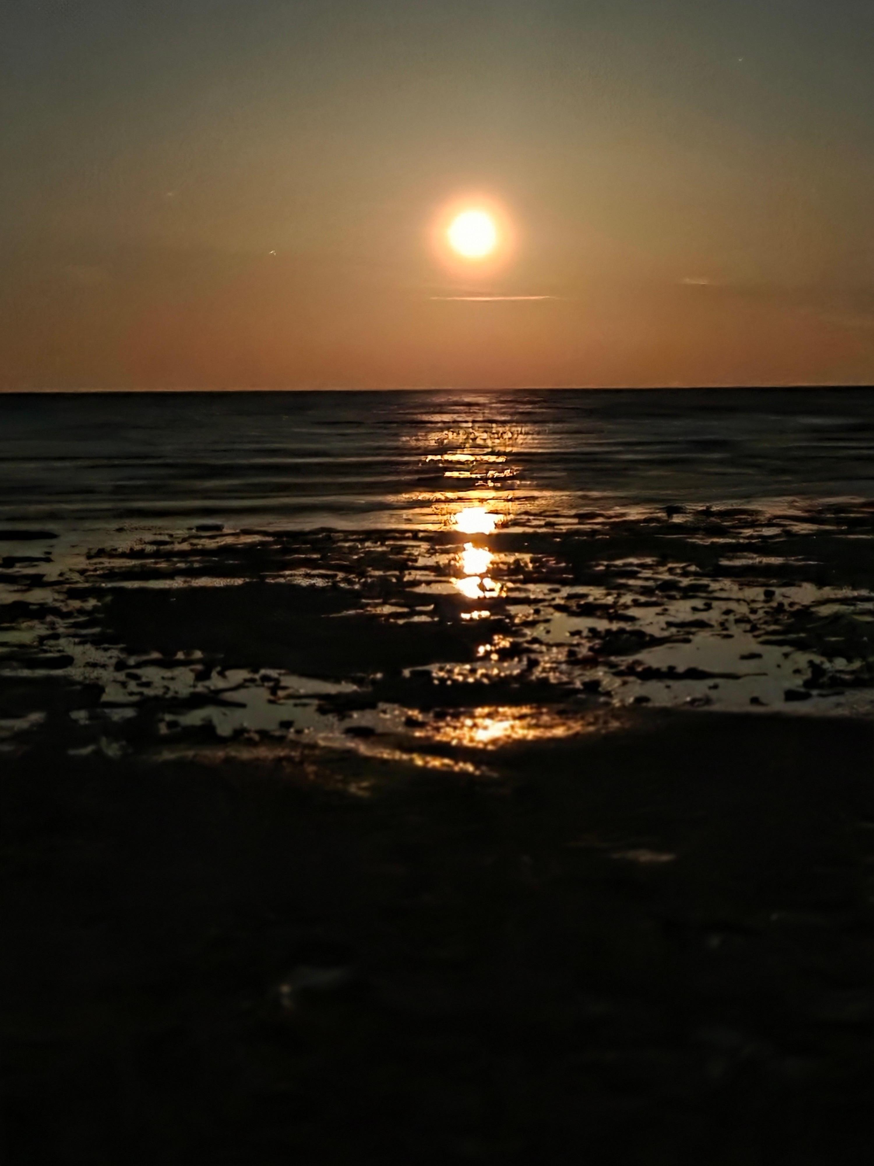 The view from the shore with the moons reflection.