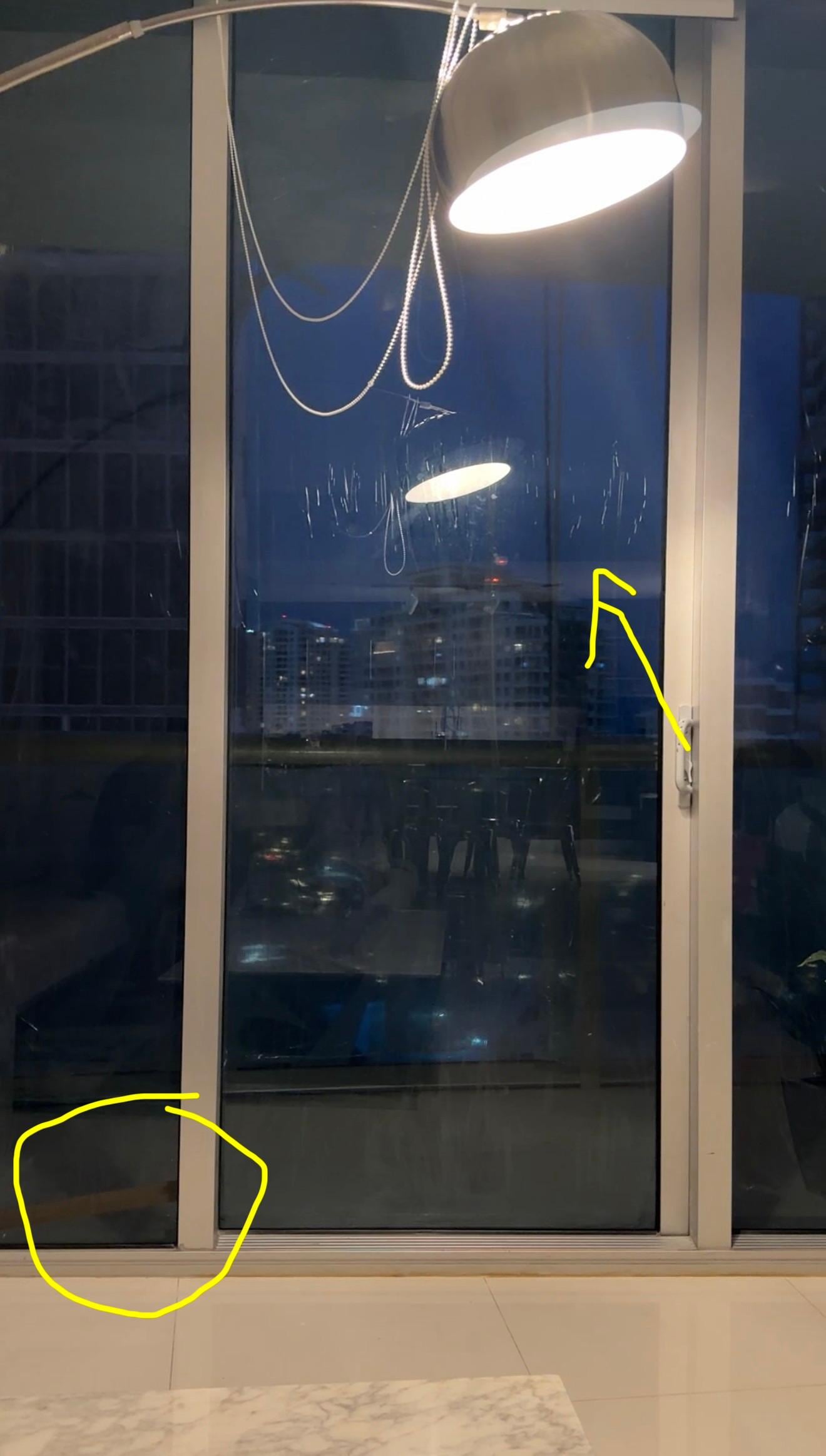 The circle shows the wedge keeping the balcony door shut & the arrow points to the film all over the windows.