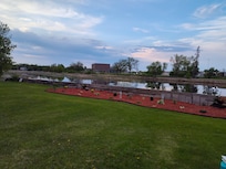 Long view of lawn, landscaping, and river from the backyard chairs.
