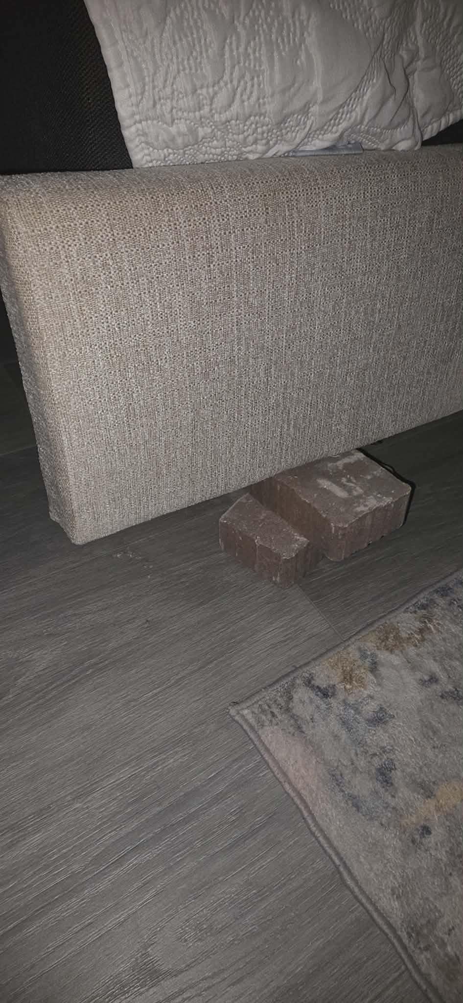 Broken bedframe making the bed uneven. Used brick to try and level bed