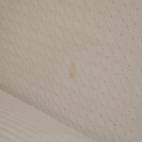 Makeup stain on wall beside bed