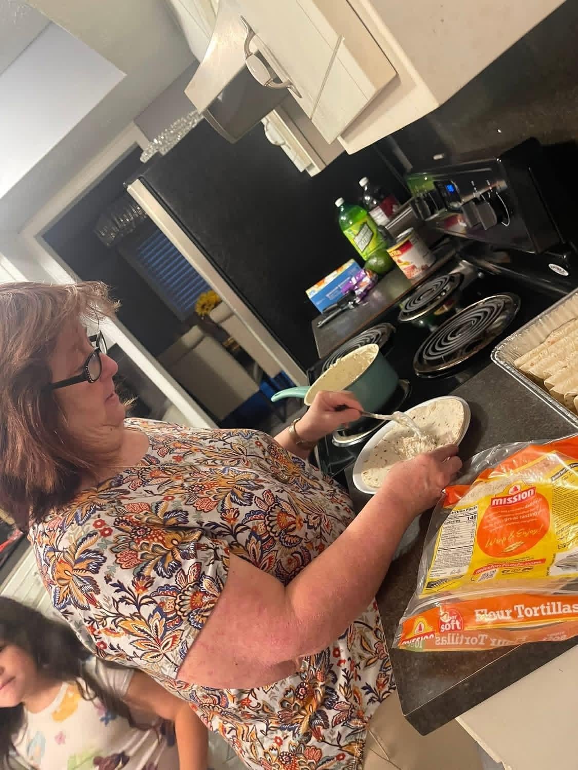 My mother cooking in the kitchen.