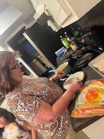 My mother cooking in the kitchen.