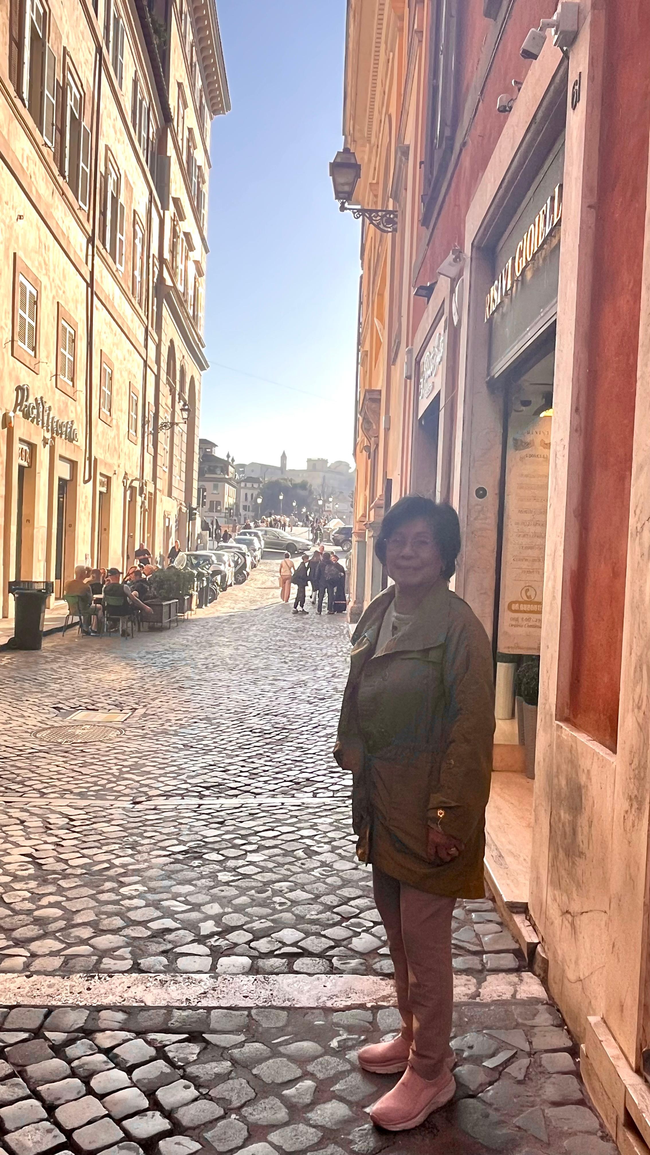 Mom standing outside the Hotel . You can see the bridge going over to Trastevere 