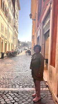 Mom standing outside the Hotel . You can see the bridge going over to Trastevere