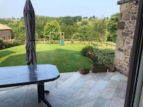 Ruime zitplaats met grote parasol en ruime tuin.