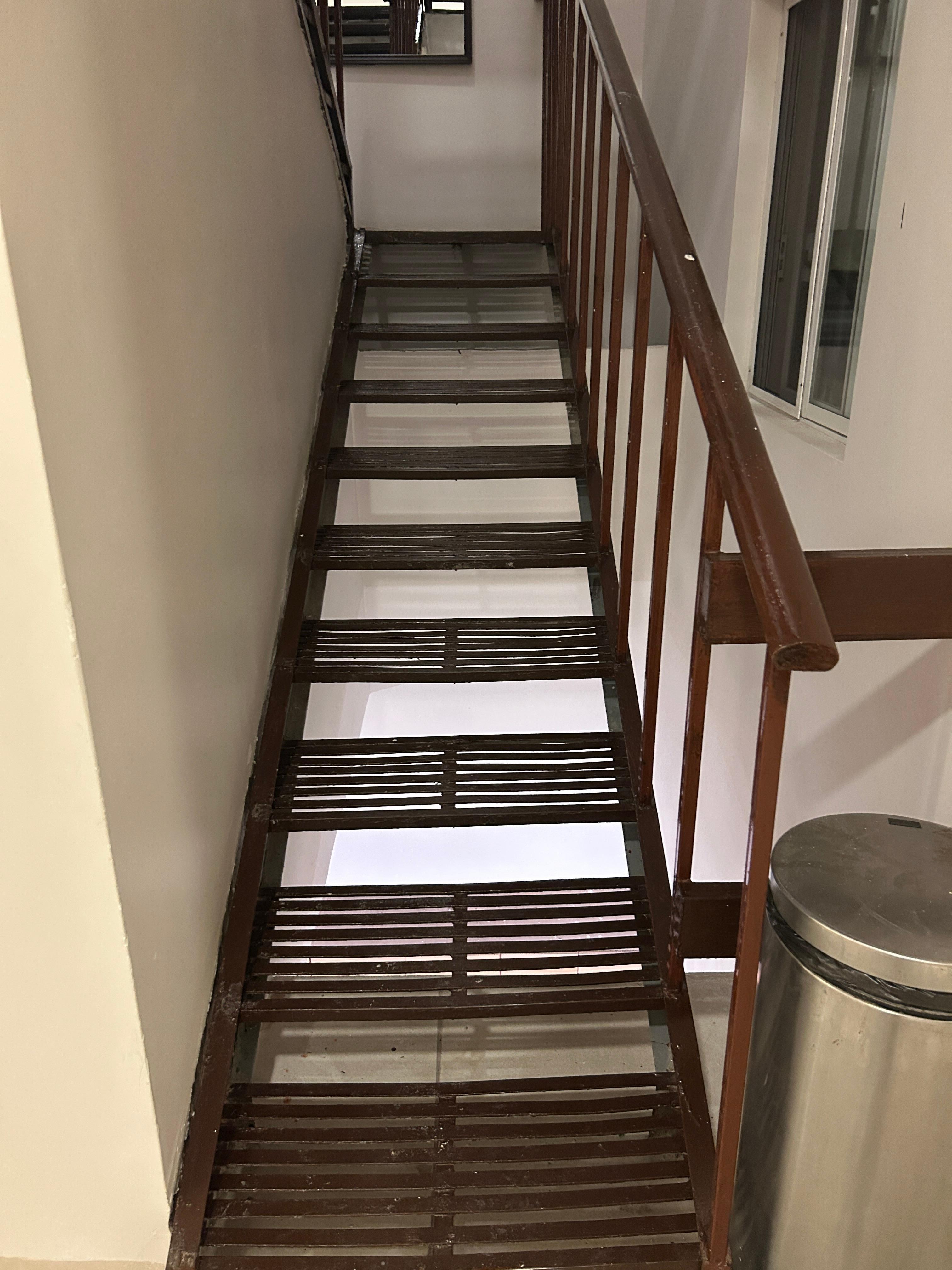 Very narrow metal staircase from second floor up