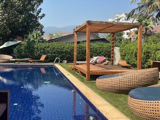 The pool area with a bunch of different chairs, many without cushions