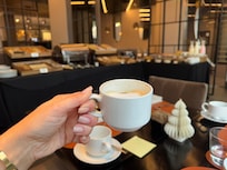 Café con Leche a lo Argentino! Breakfast buffet in background with variety of goodies.