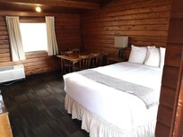 Stuen med dobbeltseng, spiseplads og køkken