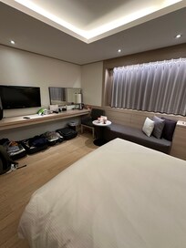 God plass i rommet med åpen koffert under bord langs veggen og en liten sofa