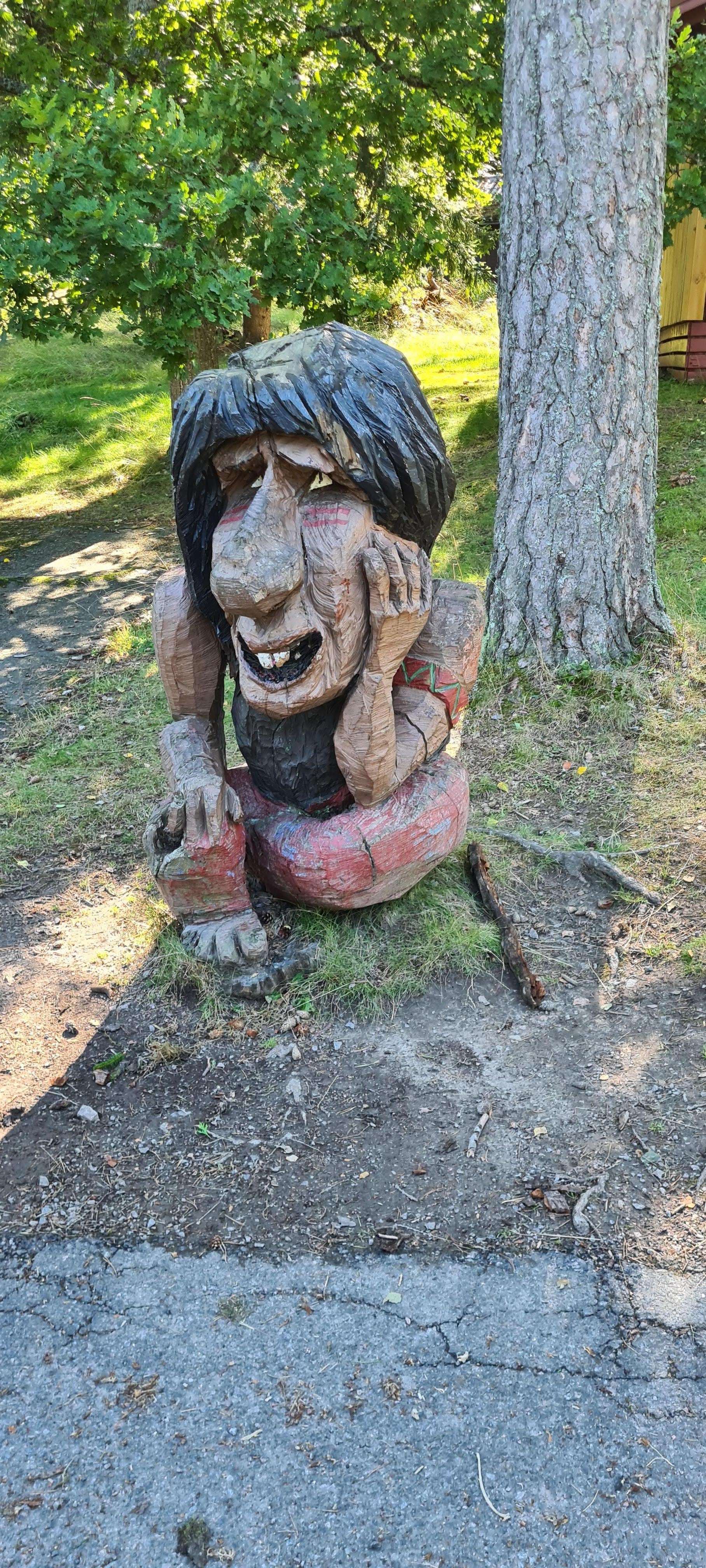 Troll framför en stuga 