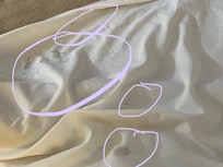 Black grease stains on bed sheet.