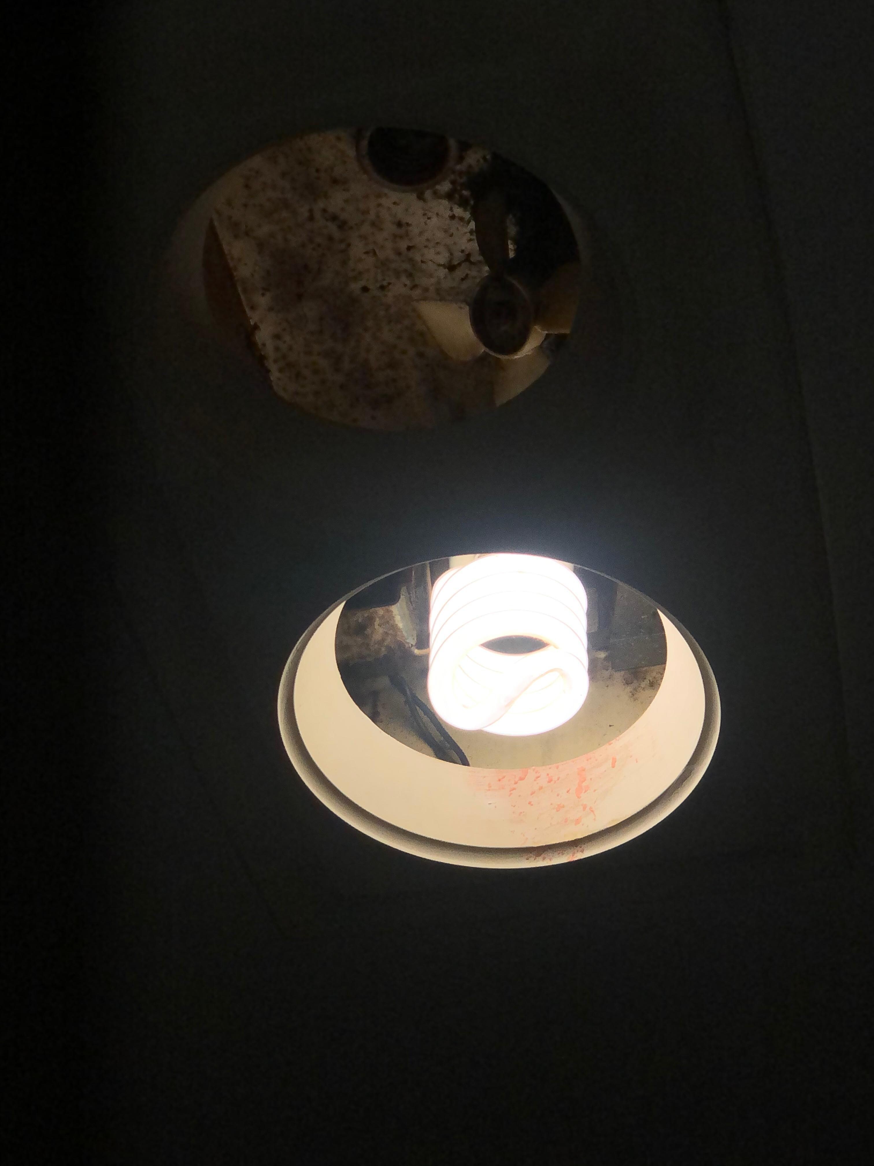 Broken bathroom light which u can see the build up or mold inside 