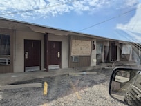 Boarded up windows. Trash outside.