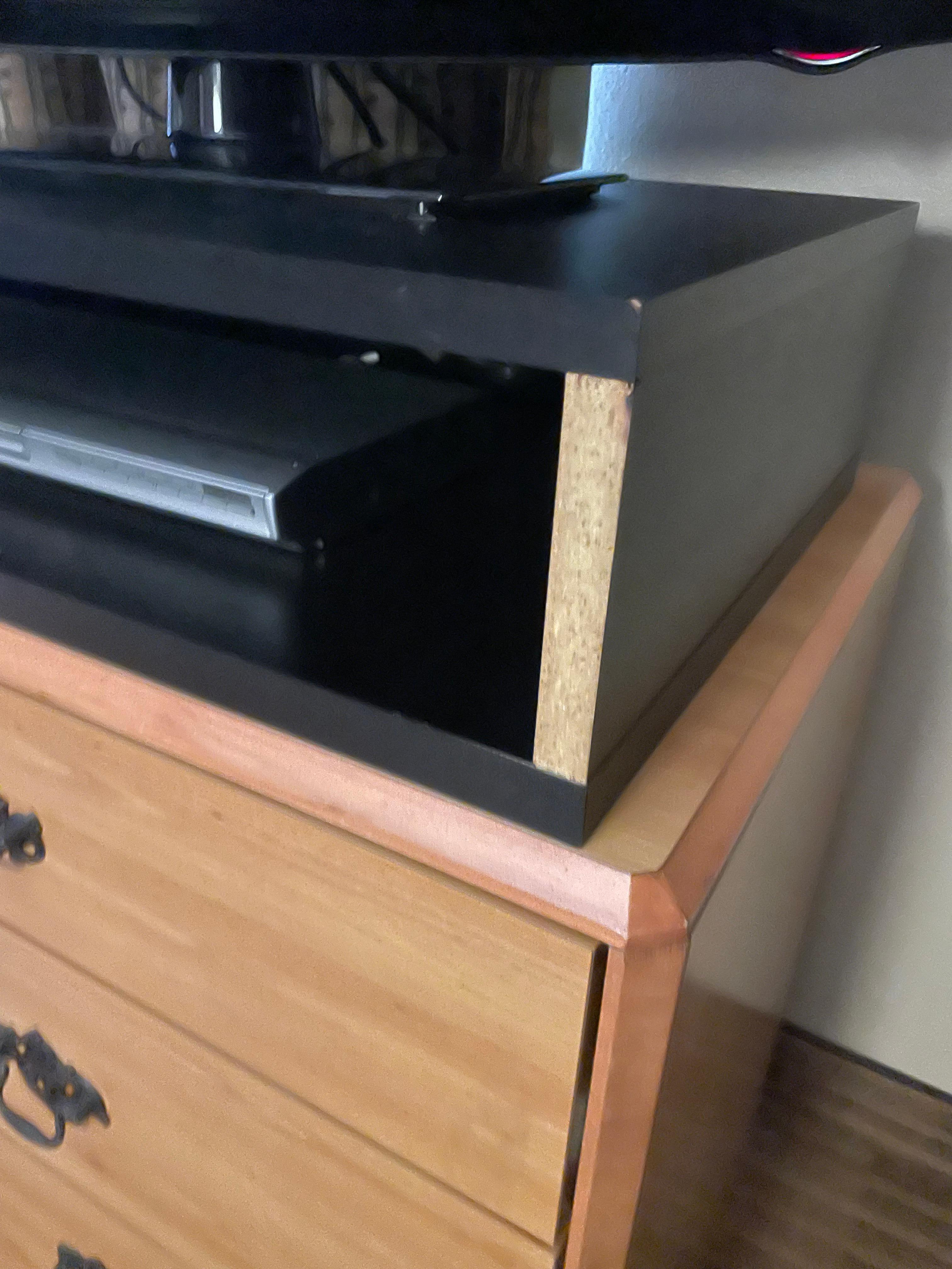 Exposed particle board on tv stand. 