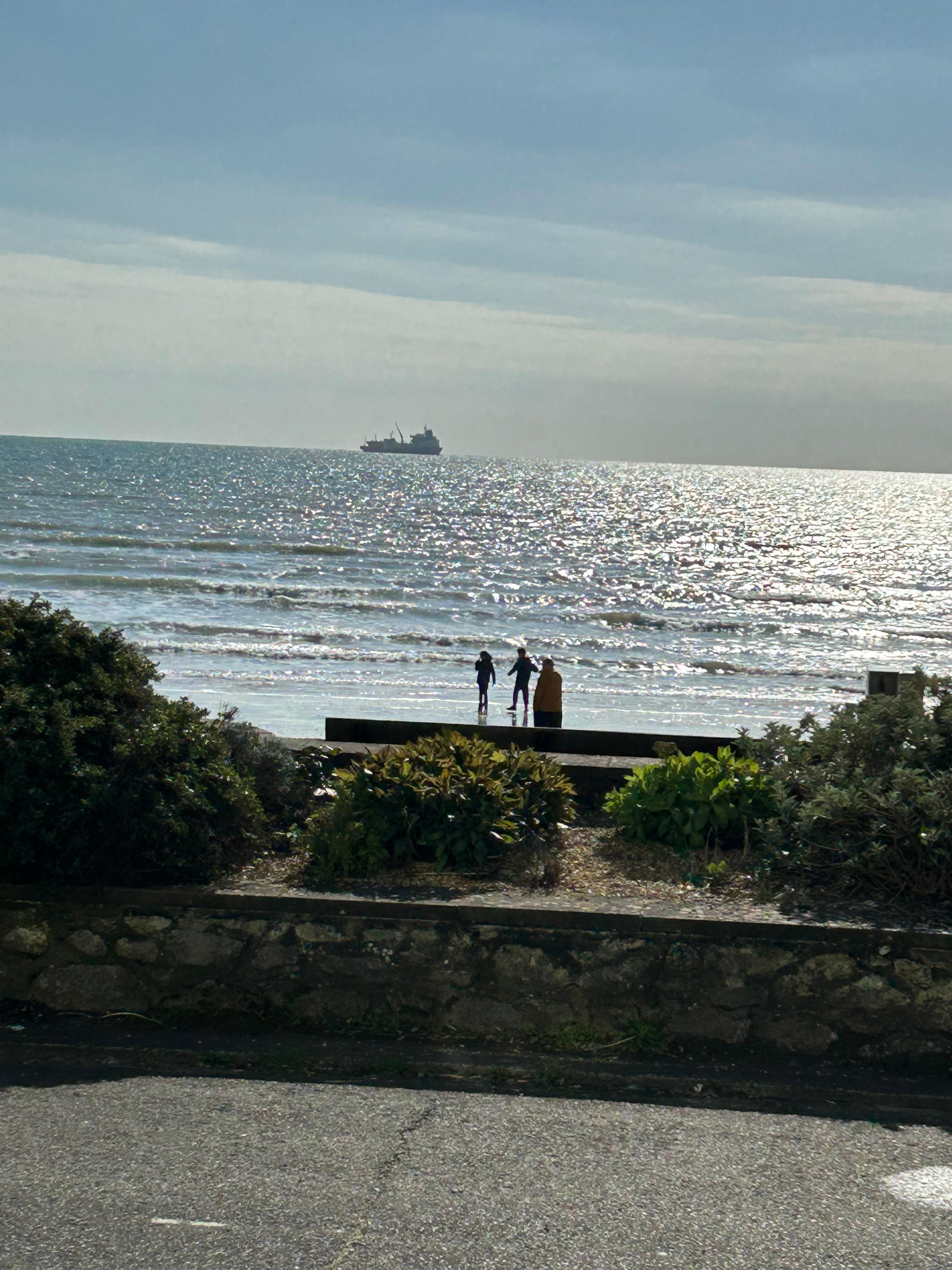 Photo of hubby and grandchildren on beach taken from our window