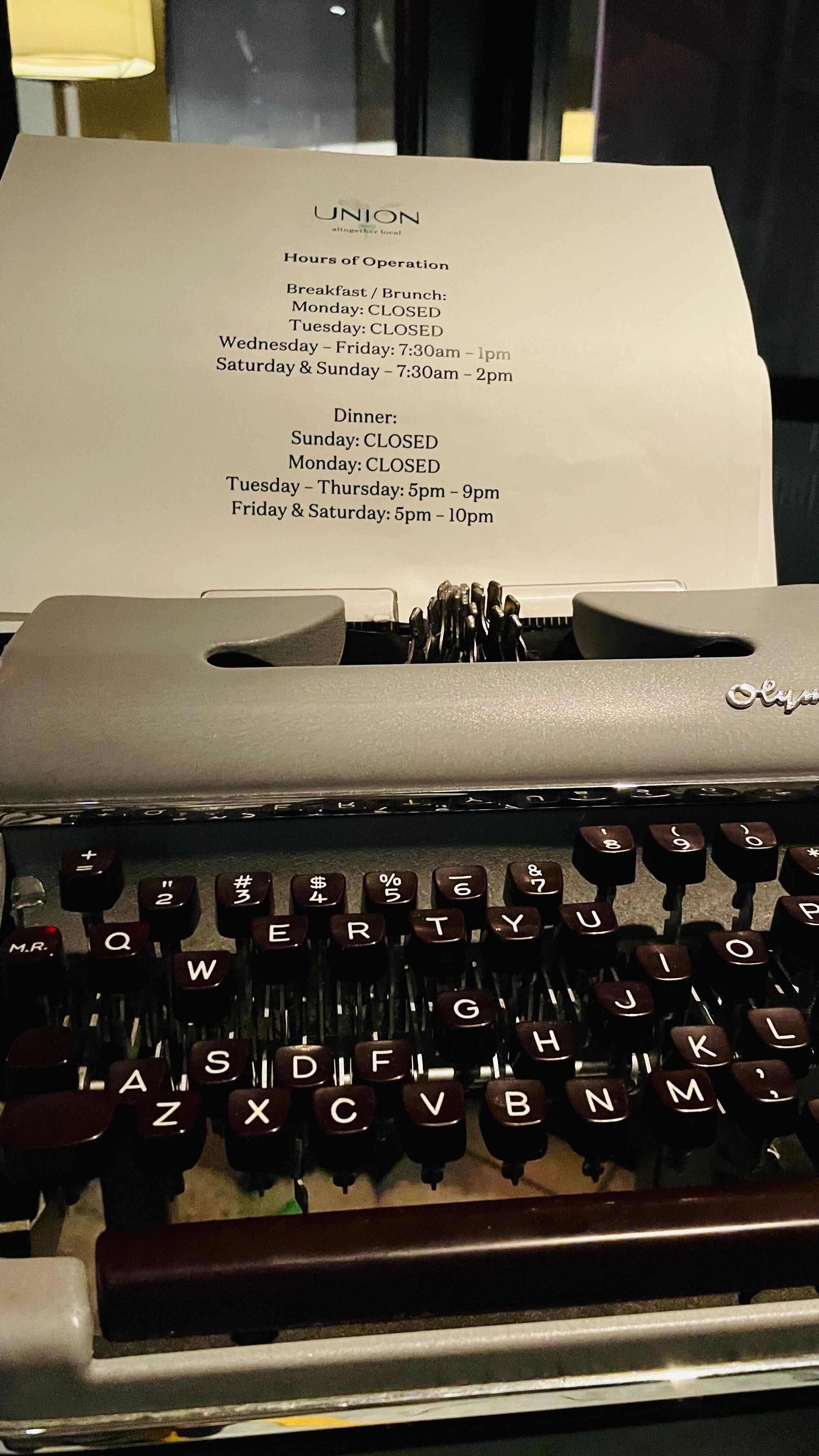 The restaurant’s hours displayed in an old typewriter.