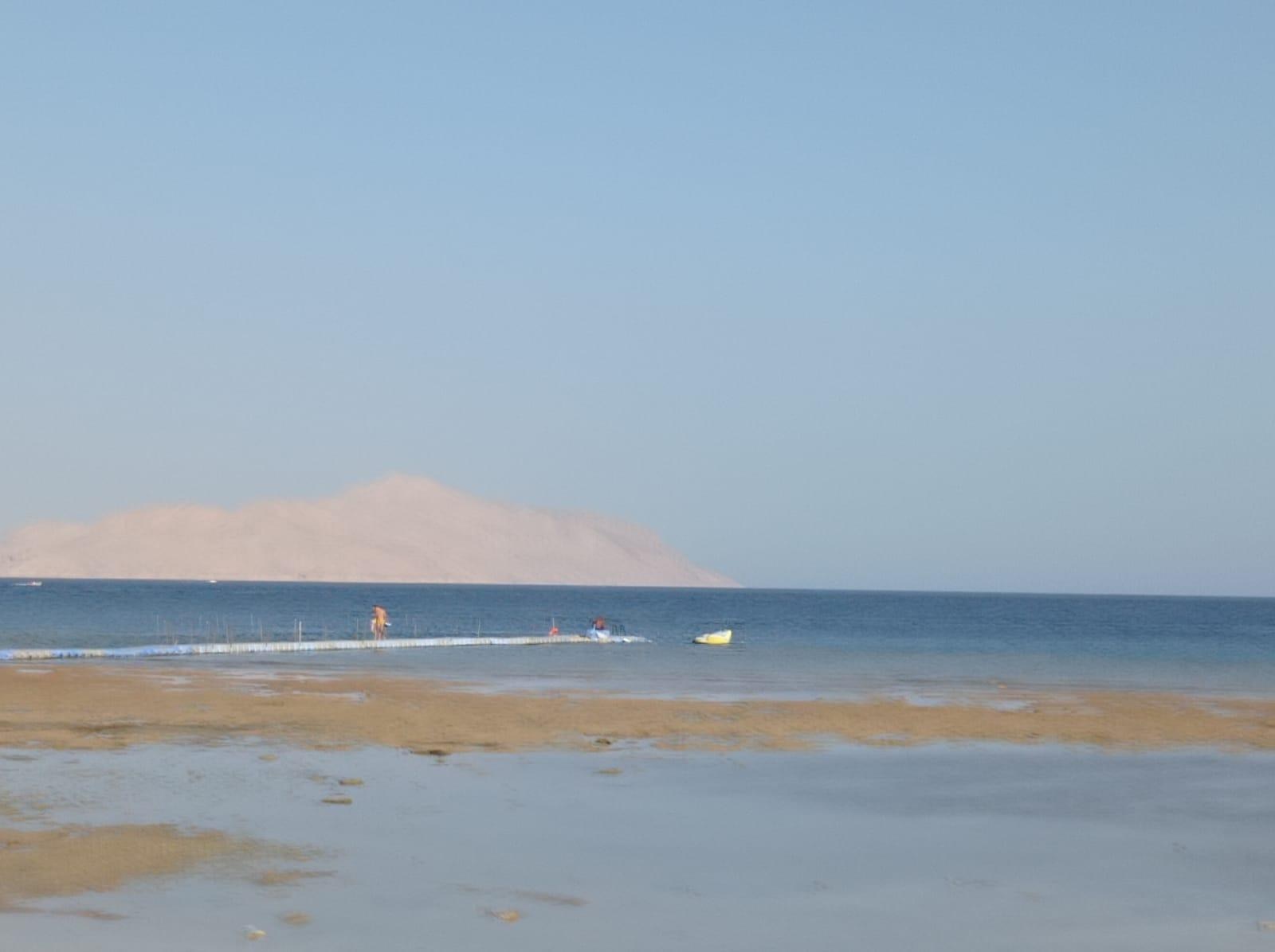 Marea baja y pasarela flotante hacia el arrecife