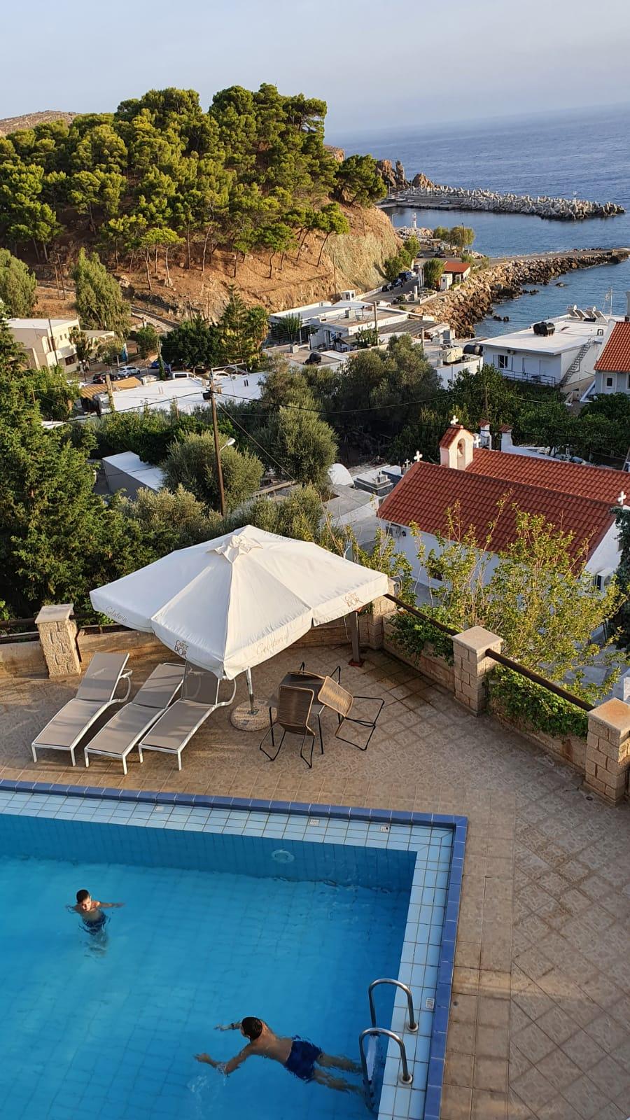 Vue de la terrasse sur la piscine de l'hôtel et le port