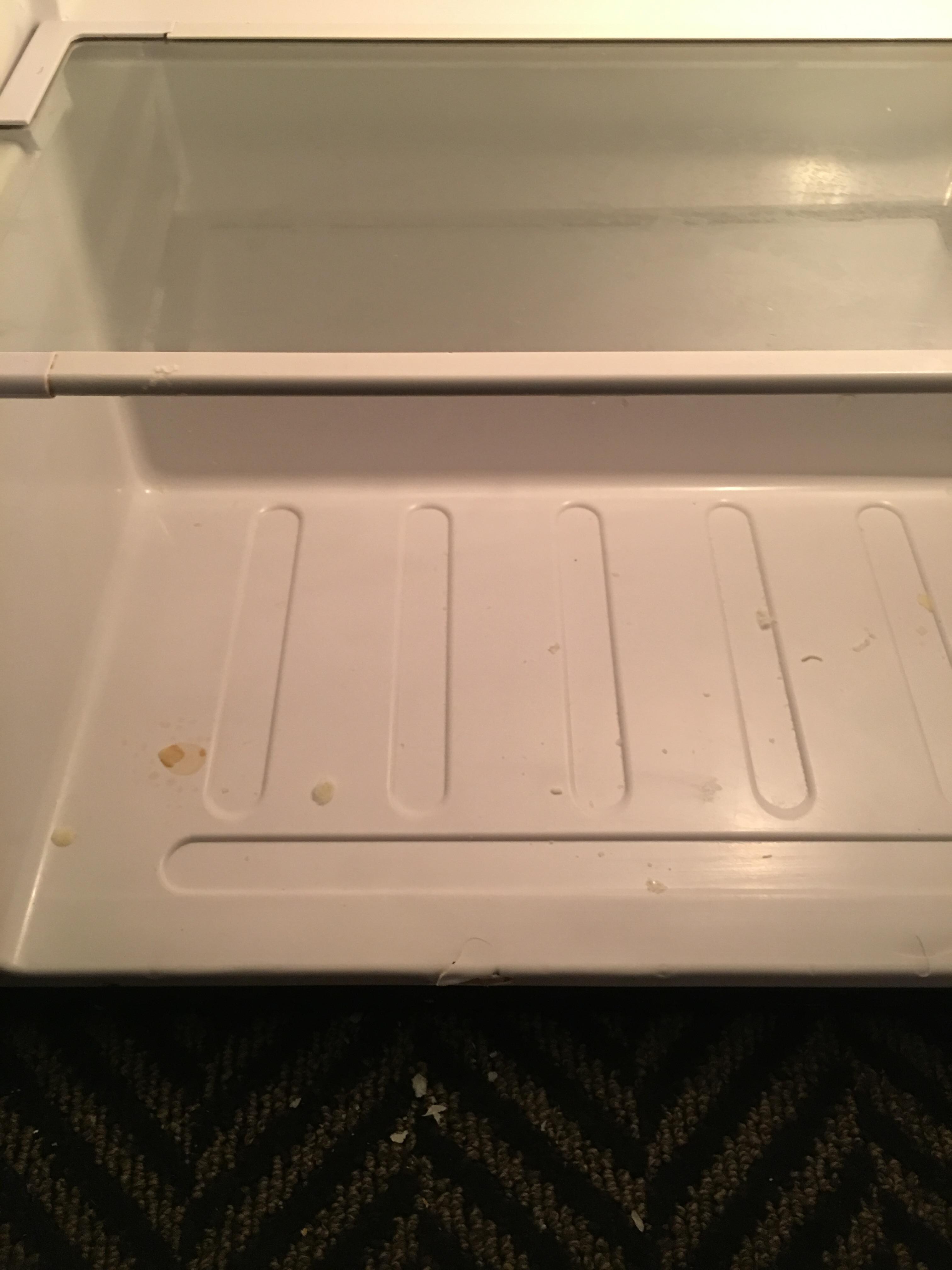 Refrigerator complete with food on carpet.