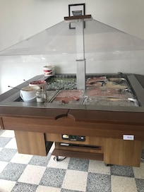 Manteiga e compotas para o pequeno almoço. Apresentação em baldes de plástico, sala pouco confortável e mal apetrechada