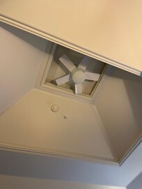 A remote controlled fan above the bed