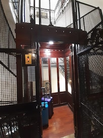 Elevador em que você fecha as portas com grades, de madeira bem frágil