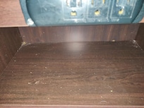 Bedside desk area covered in crumbs, dust and debris