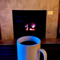 Enjoying a cup of tea (which was provided in the room) by the fireplace in our room