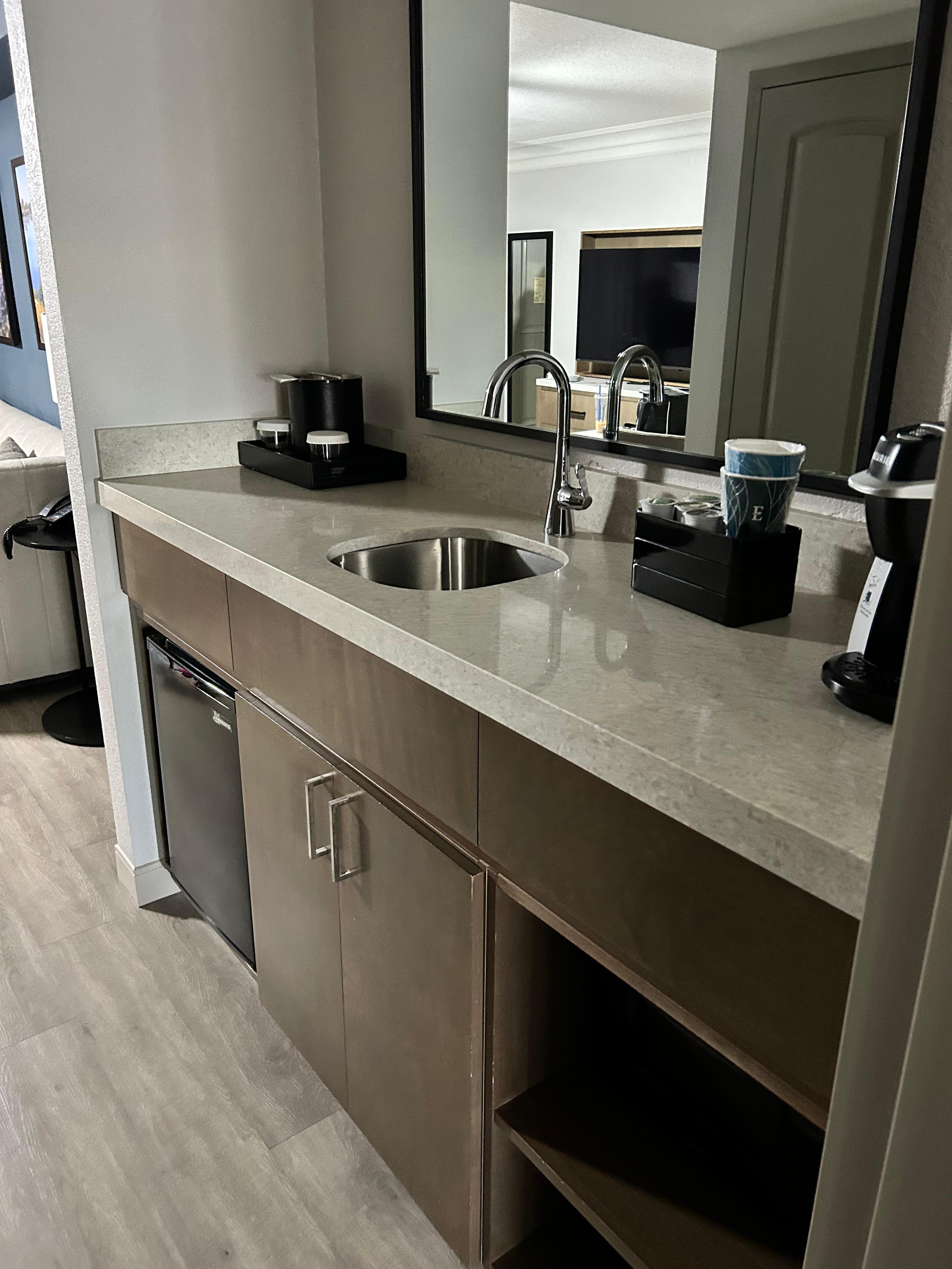 Small kitchen area with fridge and coffee pot